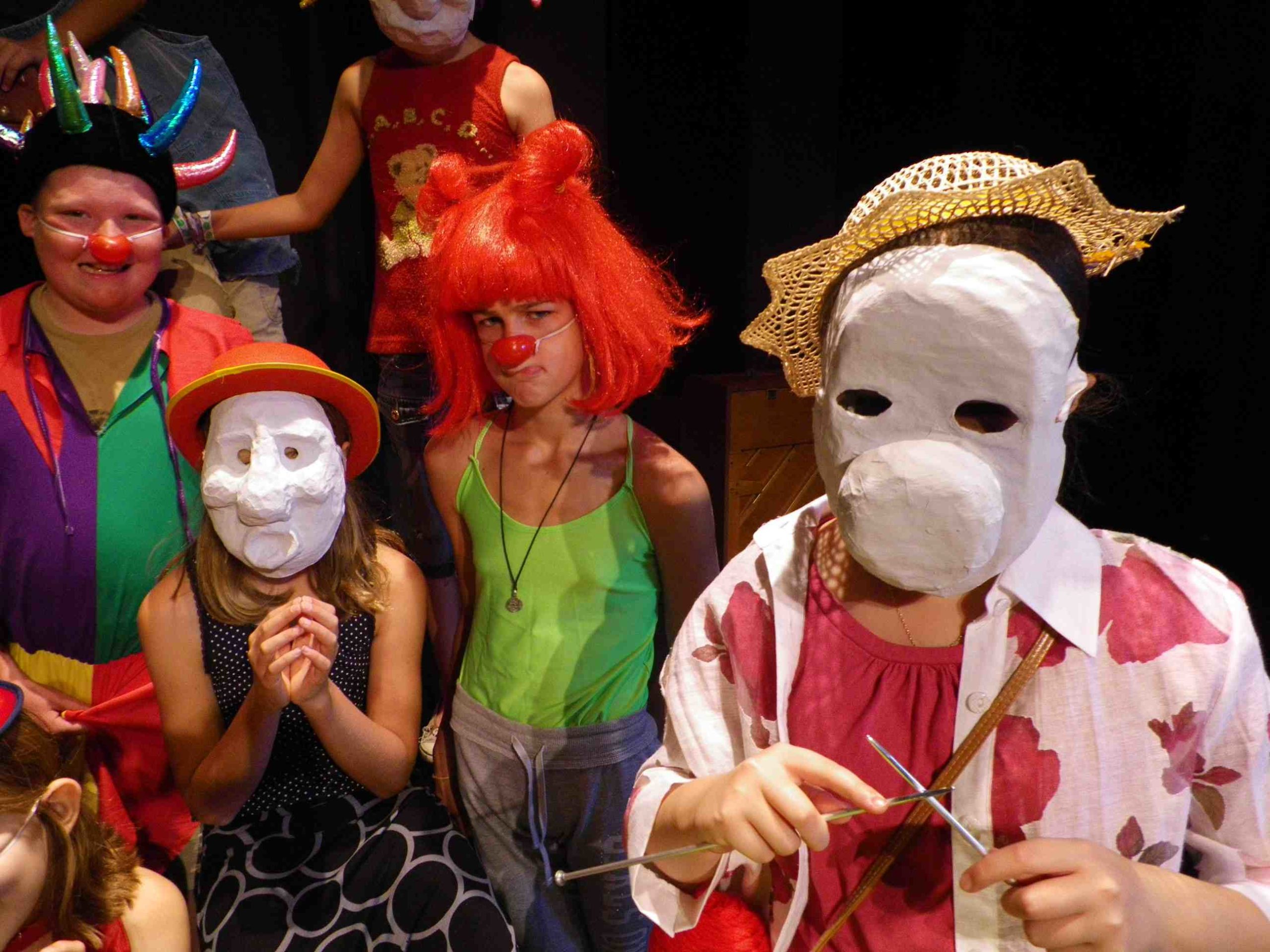 A group of children wearing masks and hats. / Un groupe d’enfants déguisés avec des masques et des chapeaux.