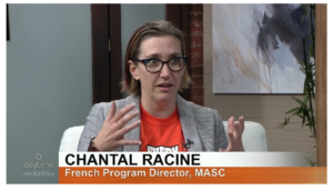 A White woman with glasses gestures with her hands as she speaks on TV, the text below her reads: Chantal Racine, French Program Director, MASC. / Une femme Blanche avec des lunettes lève ses mains en parlant à la télévision, le texte se lit: Chantal Racine, Directrice de la Programmation Francophone, MASC.